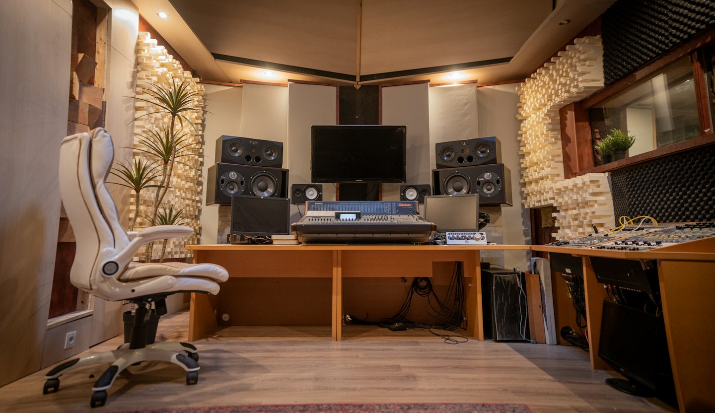 Music recording studio control room with mixing console and monitors.